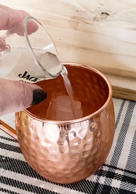 pouring vodka into mule mug